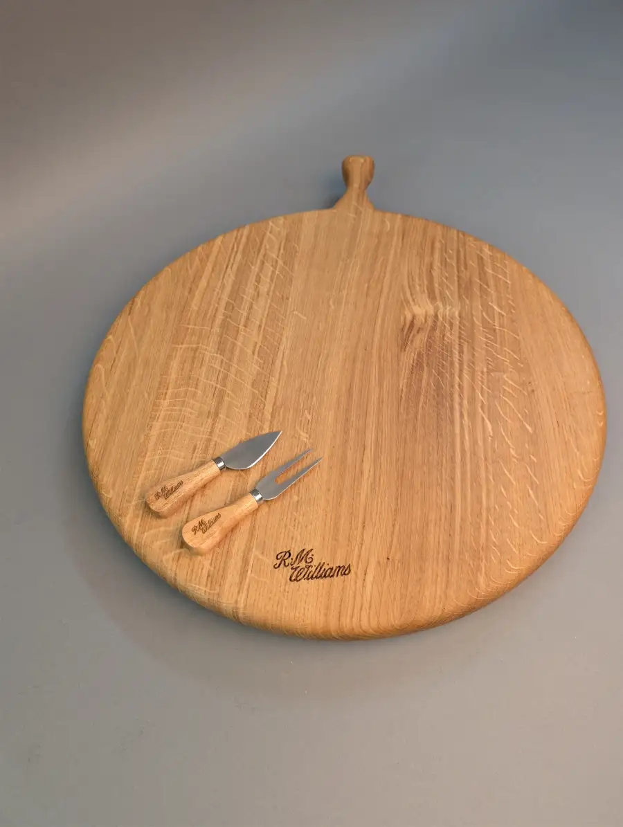 Large round custom-engraved wooden cheese board with handle, featuring the R.M. Williams logo.