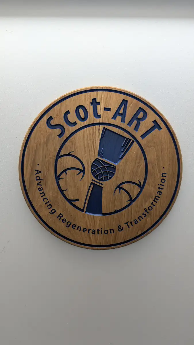 Custom round wooden business sign with 3D carved logo and blue lettering for Scot-ART, made in Edinburgh.
